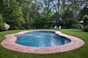 heated-gunite-pool-surrounded-by-brick-patio-showcases-beautifully-landscaped-backyard Heated gunite pool surrounded by brick patio showcases beautifully landscaped backyard